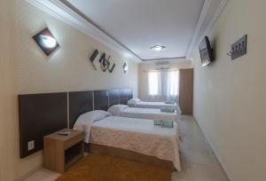 A bed or beds in a room at Monte Serrat Hotel