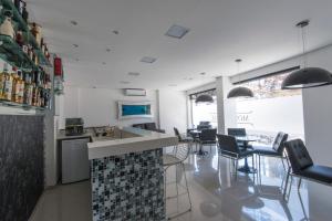 uma cozinha com balcão e cadeiras em uma sala em Monte Serrat Hotel em Santos