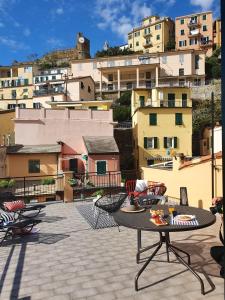 a patio with a table and chairs and buildings at Cà Vivaldi penthouse 5terreparco in Riomaggiore