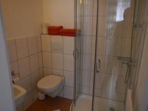 a bathroom with a toilet and a glass shower at Appartementhaus Eiergrogstube in Helgoland