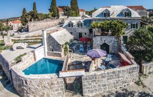 uma vista aérea de uma casa de pedra com uma piscina em Holiday house Villa Glicinia with hydro-massage pool em Donji Humac