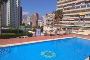 duży niebieski basen obok niektórych budynków w obiekcie APARTAMENTO RINCÓN DE LOIX ( PLAYA DE LEVANTE) w mieście Benidorm