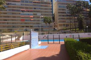 basen z ogrodzeniem i budynek w obiekcie APARTAMENTO RINCÓN DE LOIX ( PLAYA DE LEVANTE) w mieście Benidorm