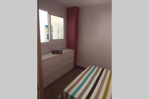 mała sypialnia z łóżkiem i oknem w obiekcie APARTAMENTO RINCÓN DE LOIX ( PLAYA DE LEVANTE) w mieście Benidorm +15 zdjęć