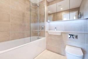 a bathroom with a tub and a toilet and a sink at LUXURY SERVICED APARTMENTS***** in Croydon