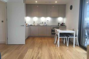a kitchen with a table and a white table and chairs at LUXURY SERVICED APARTMENTS***** in Croydon