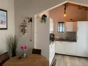 a kitchen with a wooden table and white cabinets at Beach house Atlantique 400m de la plage in Le Bois-Plage-en-Ré +14 photos
