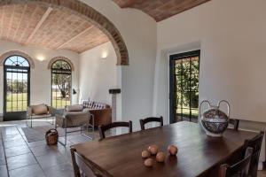 a living room with a wooden table and chairs at Podere Le Coppiole in Montalcino