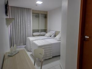 Habitación con 2 camas y una silla. en Aracaju Corais Hotel, en Aracaju