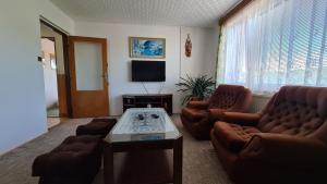 ein Wohnzimmer mit 2 Sofas und einem TV in der Unterkunft Privát Kučera in Vysoké nad Jizerou
