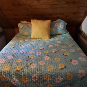 a bed with a blue bedspread with flowers on it at Grey Squirrel Resort in Big Bear Lake
