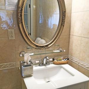
a bathroom with a large mirror and a sink at Morris House Hotel in Philadelphia
