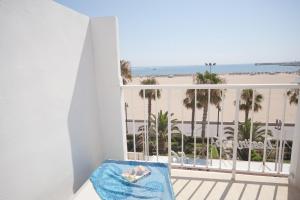 a balcony with a view of the beach and palm trees at Sol Playa Suites in Valencia