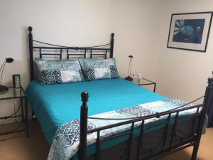 - une chambre avec un lit doté de draps et d'oreillers bleus dans l'établissement Mark's View, à KwaDukuza
