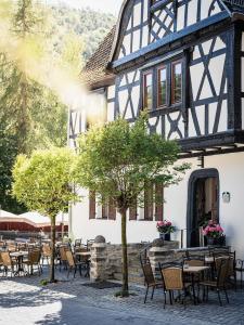 Landgasthof zur Burg Grenzau في هور-غرنتسهاوزن: مبنى به طاولات وكراسي في ساحة