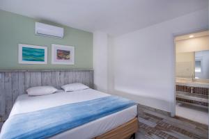Un dormitorio con una cama y un baño con bañera. en Ilhabela Beach Residences, en Ilhabela 93 fotos más