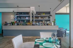 een eetkamer met een tafel en stoelen en een bar bij Boulevard Studio's with side seaview in Laganas