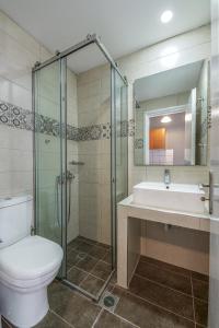 a bathroom with a toilet and a sink and a tub at Boulevard Studio's with side seaview in Laganas