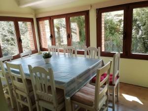 a dining room with a table and chairs and windows at Casa Carlota in Cabó