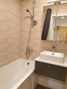 a bathroom with a tub and a sink and a shower at Sun apartments in Anykščiai +4 photos