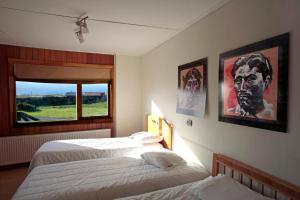 1 dormitorio con 2 camas y ventana en Cabañas Patagonia Encantada en Puerto Natales