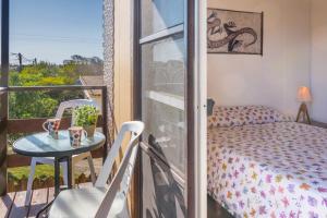 1 dormitorio con balcón con 1 cama y 1 mesa en Las yolandas, en La Paloma