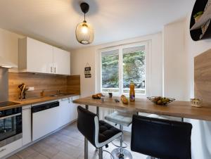 uma cozinha com armários brancos e um balcão de madeira em - Les Berges du Pont Valentré - em Cahors