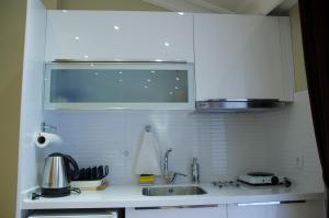 a white kitchen with a sink and a microwave at Art Nouveau Galata in Istanbul