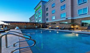 a large swimming pool in front of a hotel at Holiday Inn Austin Airport by IHG in Austin
