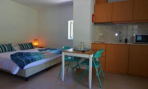 um quarto com uma cama e uma mesa e uma cozinha em Aldeia do Tâmega em Amarante