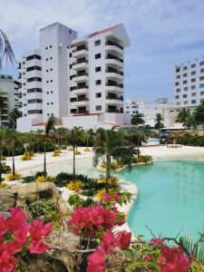 a resort with a swimming pool in front of buildings at Hotel Arena Blanca by Dorado in San Andrés