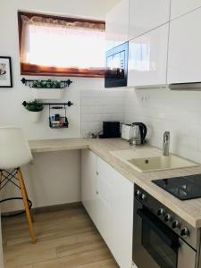 凱奇凱梅特的住宿－Belvárosi Stúdió Apartman，厨房配有白色橱柜和台面
