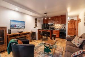 eine Küche und ein Wohnzimmer mit einem Sofa und einem Tisch in der Unterkunft Vantage Point Lionshead by Vail Realty in Vail