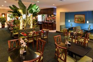 Un restaurante con mesas y sillas y un bar. en Holiday Inn Montgomery South Airport by IHG, en Hope Hull