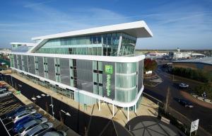 a large building with cars parked in a parking lot at Holiday Inn Southend by IHG in Southend-on-Sea