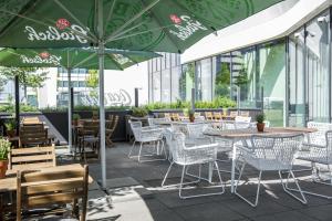 a restaurant with tables and chairs and green umbrellas at Holiday Inn Amsterdam - Arena Towers by IHG in Amsterdam