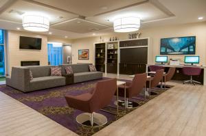 a living room with a couch and a table and chairs at Holiday Inn - New Orleans Airport North by IHG in Kenner