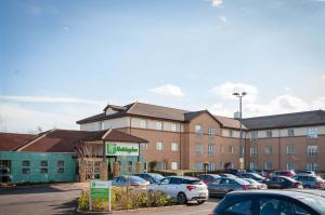 a building with cars parked in a parking lot at Holiday Inn Darlington - NORTH A1M, JCT.59, an IHG Hotel in Darlington