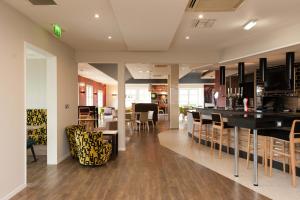 ein Esszimmer und eine Küche mit einer Bar und Stühlen in der Unterkunft Holiday Inn Darlington - NORTH A1M, JCT.59 by IHG in Darlington