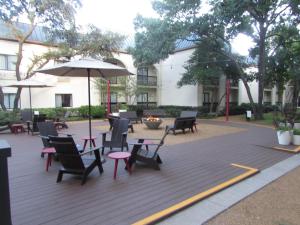 a patio with chairs and tables and an umbrella at Holiday Inn Irving Las Colinas, an IHG Hotel in Irving