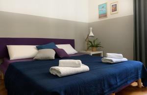 una camera da letto con un letto blu e cuscini sopra di Casa Strehler a Trieste