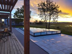 eine Terrasse mit einem Tisch und einem Baum auf der Terrasse in der Unterkunft Zimmerei - Landgasthaus Karlo in Illmitz