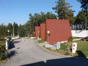 una carretera que conduce a un edificio con techo rojo en parque de campismo de Luso, en Luso