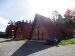 un edificio con techo rojo en parque de campismo de Luso en Luso