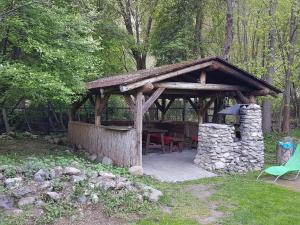 a wooden gazebo with a table and chairs at Chata pod skalou in Valaská
