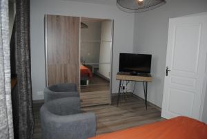 a room with a television and two chairs and a desk at Gite Le Jour J in Sainte-Mère-Église