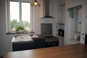 a kitchen with a sink and a stove top oven at Gite Le Jour J in Sainte-Mère-Église