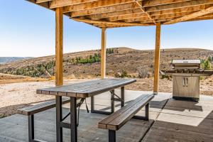 a picnic table with a grill and a barbecue at Heider Cabin in Garden City