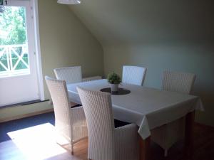 een eetkamer met een tafel en witte stoelen bij B&B Wijnendalvallei in Torhout