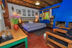1 dormitorio con 1 cama en una habitación azul en Hotel Na Bolom en San Cristóbal de Las Casas
